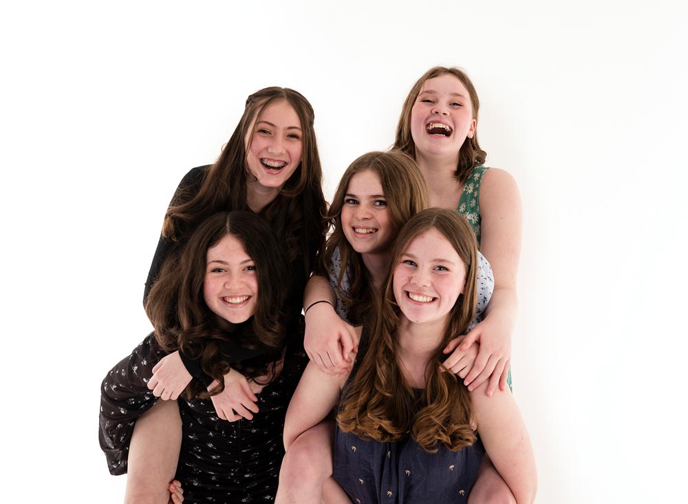 Five girls 2 giving a piggy back at a children's photoshoot party
