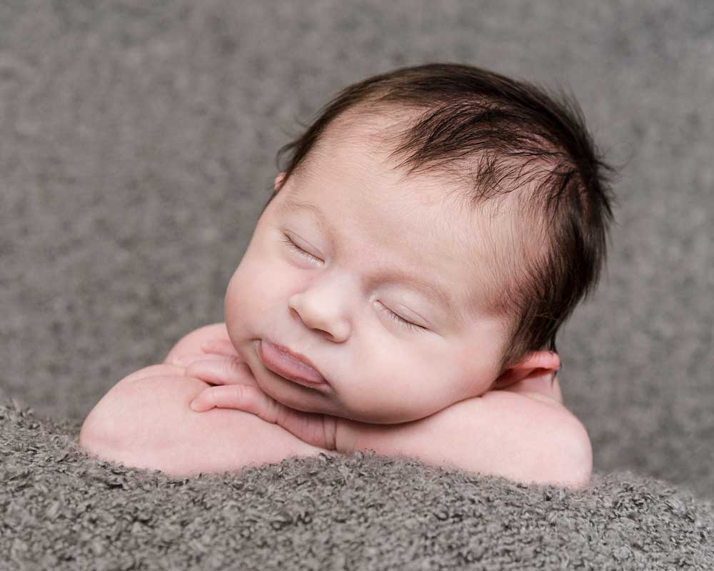 Babies head and arms asleep for a newborn photography studio photoshoot