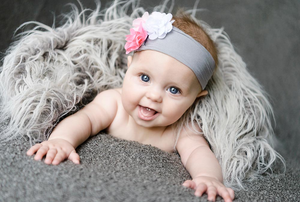 Cute Baby with a grey headband and pink flower portrait