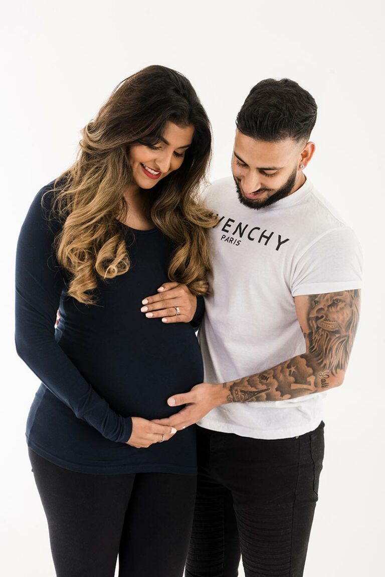 pregnant lady showing bump with partner for a bump to baby photoshoot