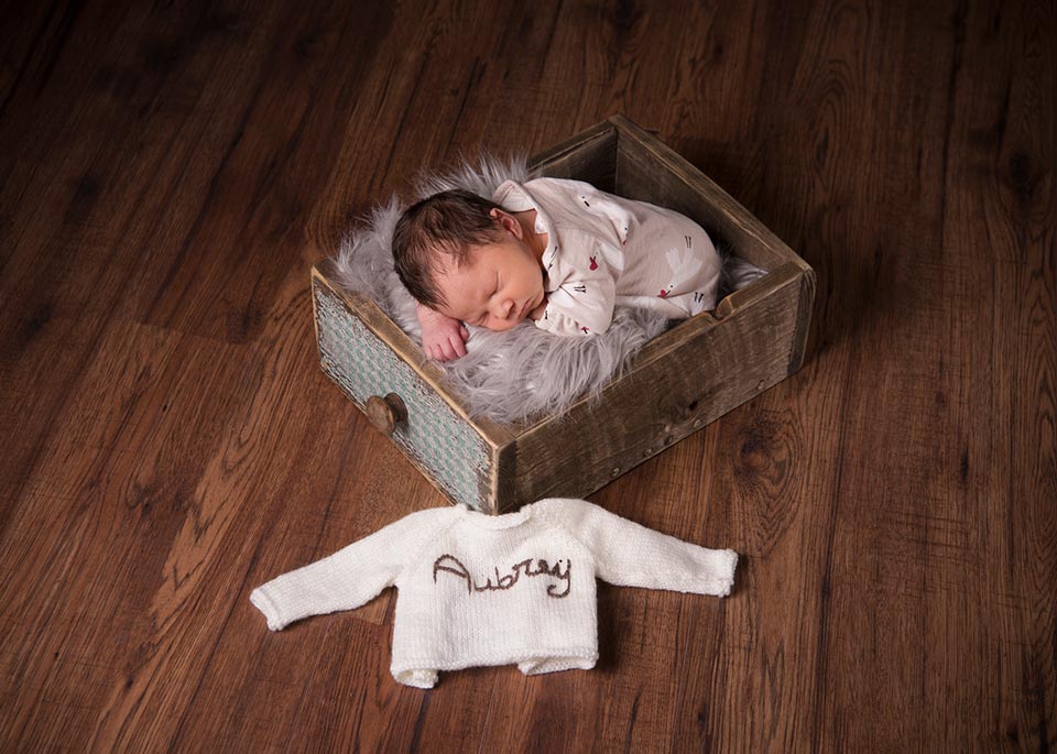 baby posing in a draw for a bump to baby portrait session