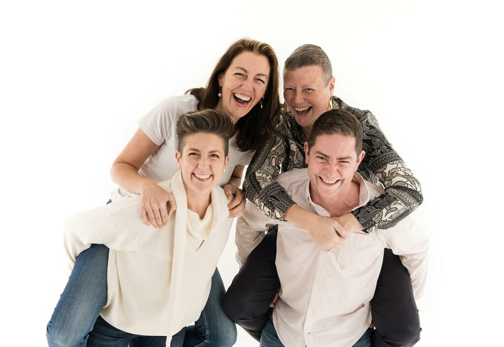 a family smiling and posing for a through the generations family photoshoot
