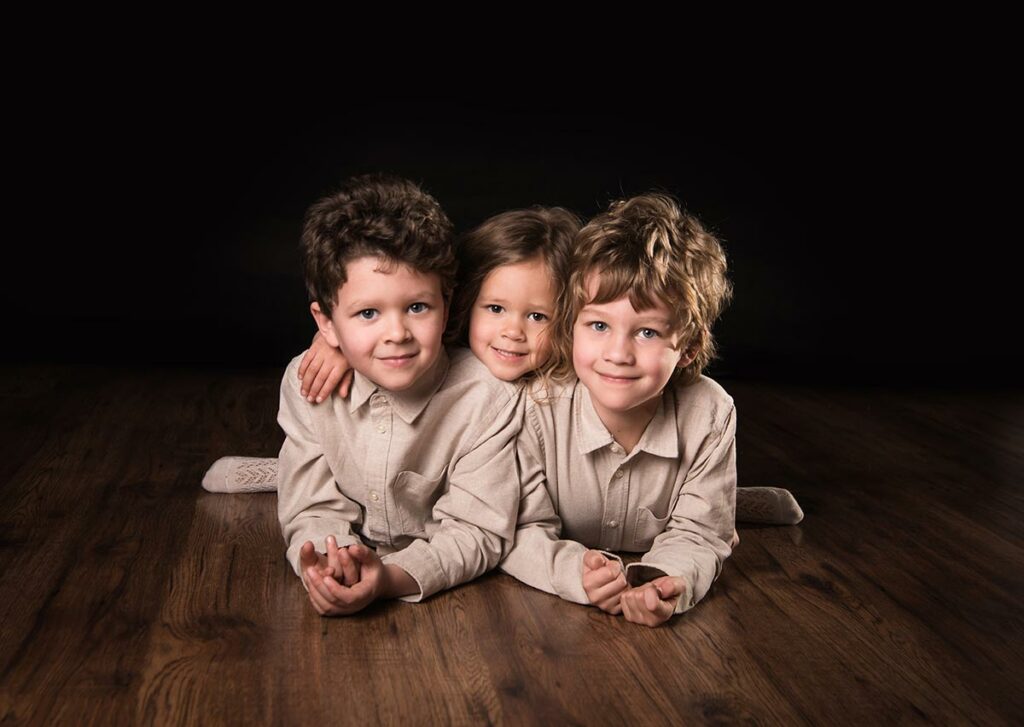 three children's photography portrait on a dark background